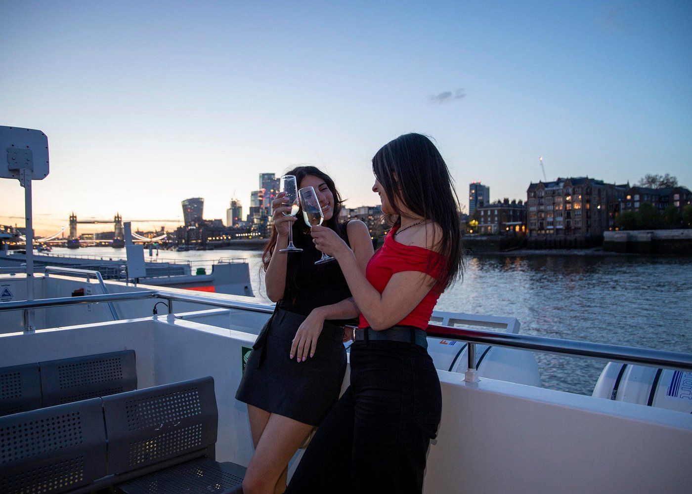 Deux jeunes femmes buvant du champagne sur le pont d'un bateau à Londres