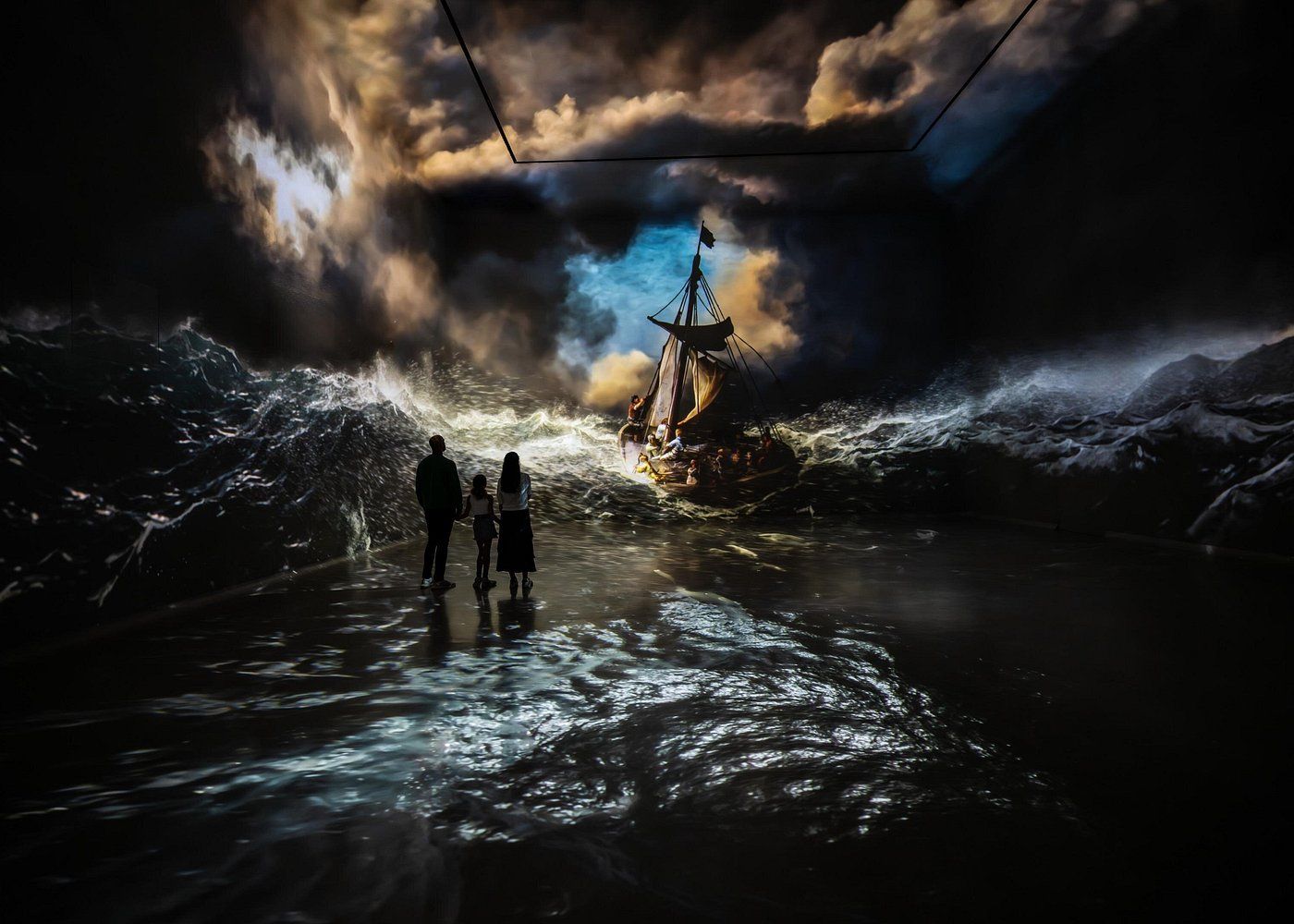 Famille devant une projection du tableau Le Christ dans la tempête sur la mer de Galilée de Rembrandt