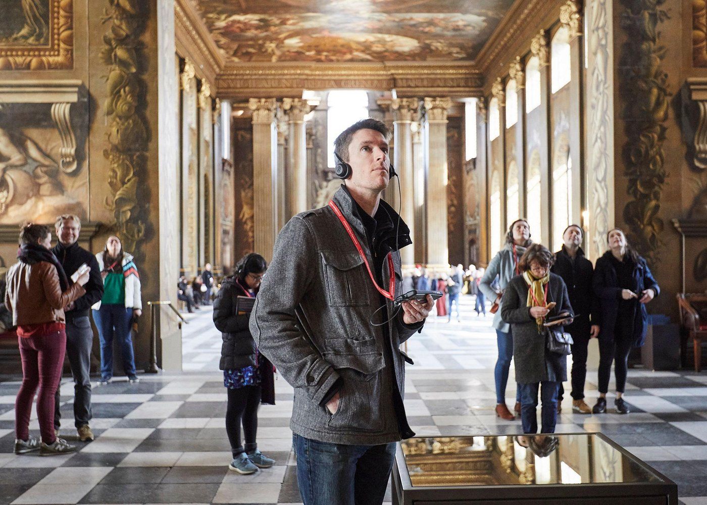 Touriste avec un audioguide dans le Painted Hall du Old Royal Naval College à Londres