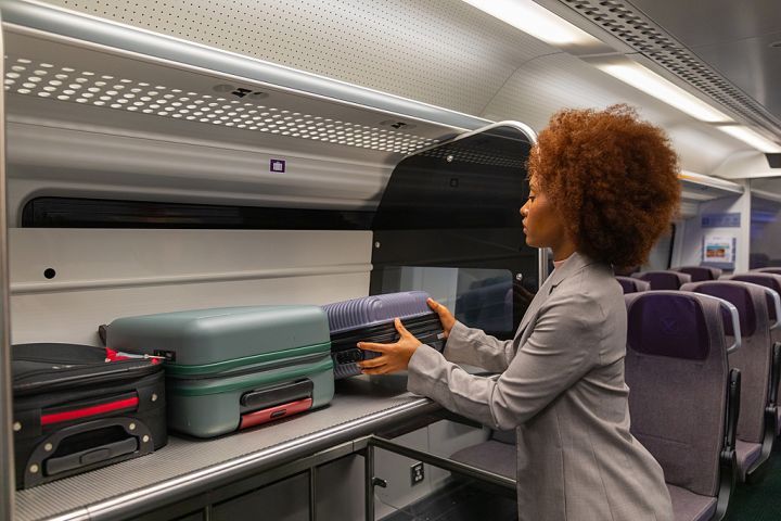 Femme posant sa valise à bord du train Heathrow Express